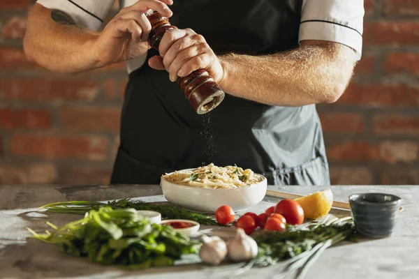 Ritratto ritagliato di chef maschile, cuoco preparare carbonara nel suo caffè, cucina del ristorante. Concetto di una dieta corretta e sana. Degustazione pasta — Foto Stock