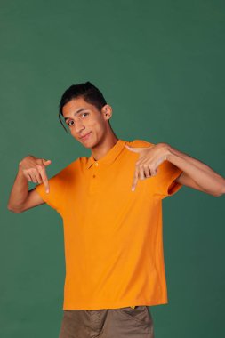 Genç yakışıklı bir adamın yarım boy portresi, yeşil vintage stüdyo arka planında izole edilmiş günlük giysiler içindeki öğrenci. İnsan duyguları kavramı.