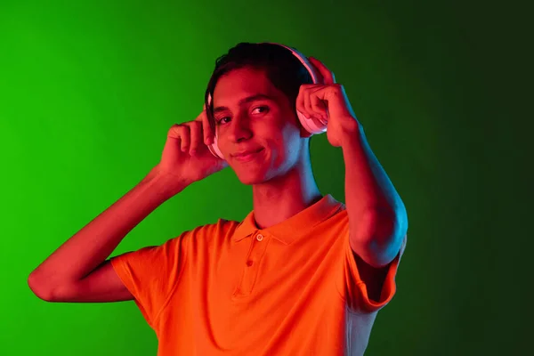 Porträtt av ung stilig man, student i casual kläder isolerad på grön vintage studio backgroud. Begreppet mänskliga känslor. — Stockfoto