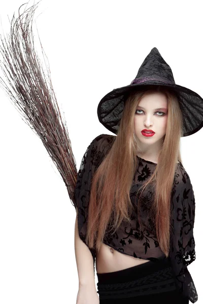 Showy young woman in witch costume with a broom — Stock Photo, Image