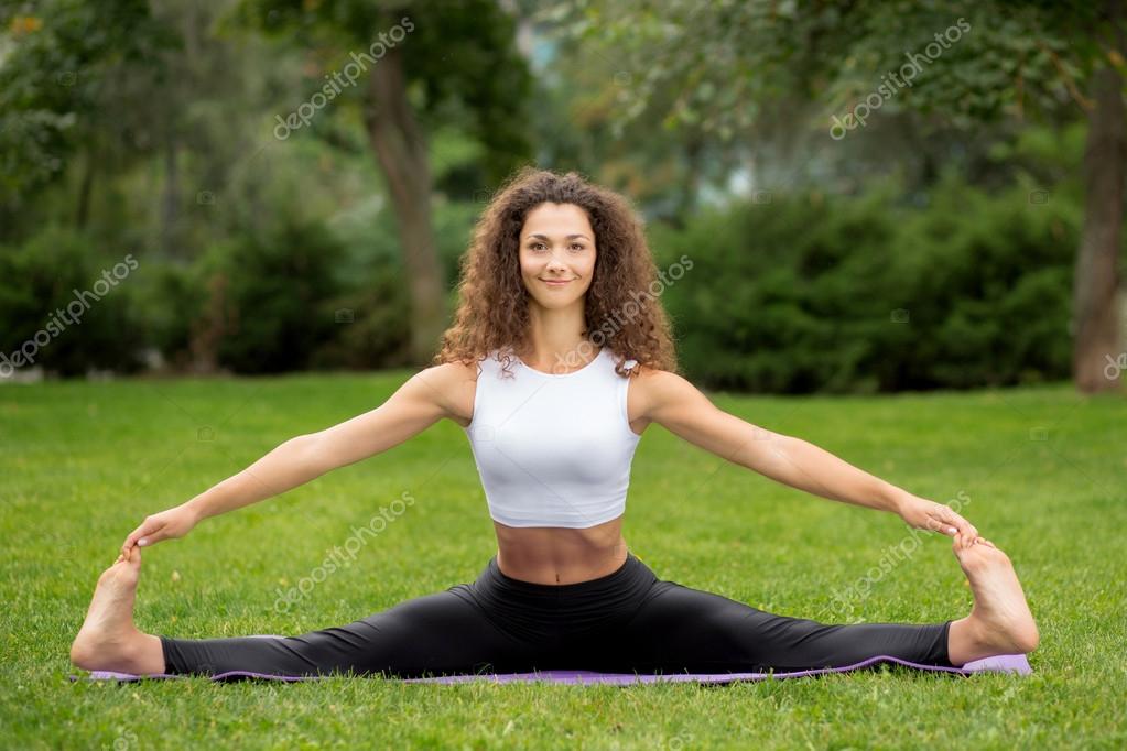 Smiling pretty woman doing yoga exercises Stock Photo by