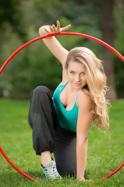 Jonge vrouwelijke atleet met hoelahoep in het park — Stockfoto