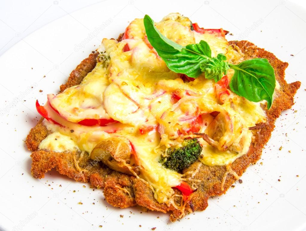 Crispy veal schnitzel with cheese, tomatoes, peppers, broccoli and
