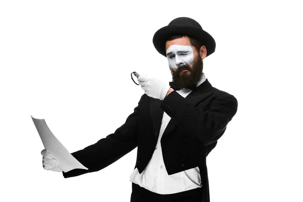 Man with a face mime reading through magnifying glass — Stock Photo, Image