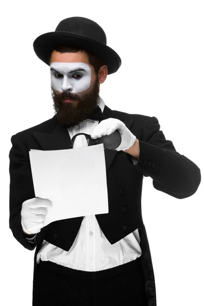 Man met een gezicht mime lezen door middel van Vergrootglas — Stockfoto