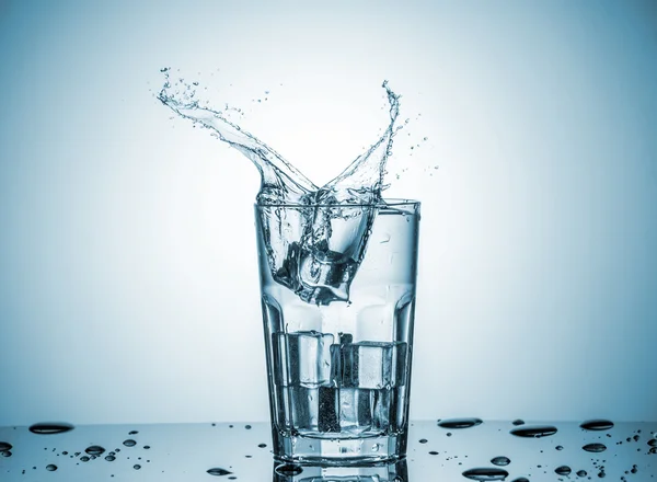 Agua en vaso con agua salpicada —  Fotos de Stock