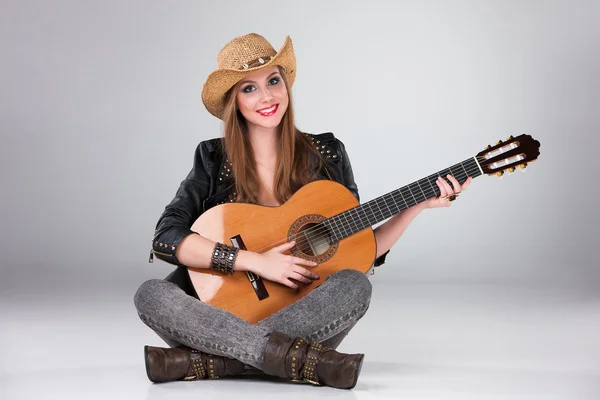 A menina bonita em um chapéu de cowboys e guitarra acústica . — Fotografia de Stock