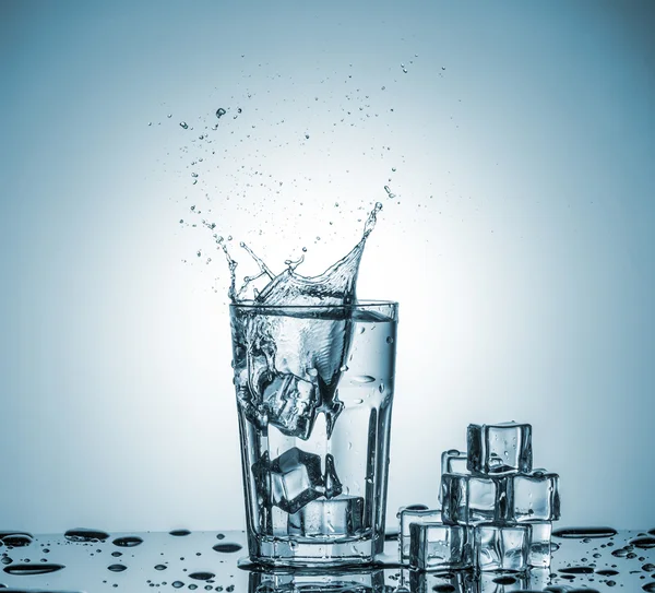 Agua en vaso con agua salpicada — Foto de Stock