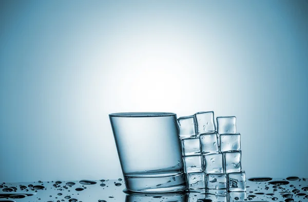 Agua en vidrio y cubitos de hielo, acostado al lado — Foto de Stock