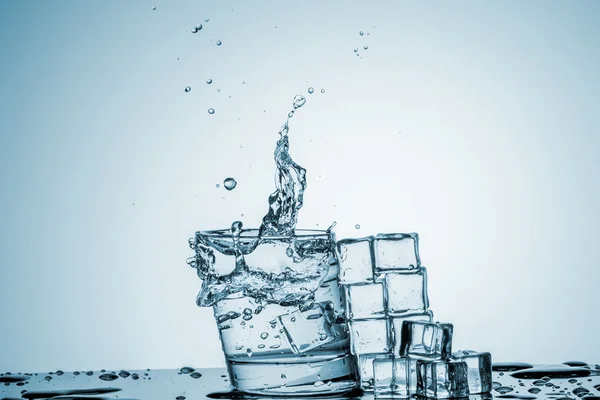 Agua en vaso con agua salpicada — Foto de Stock