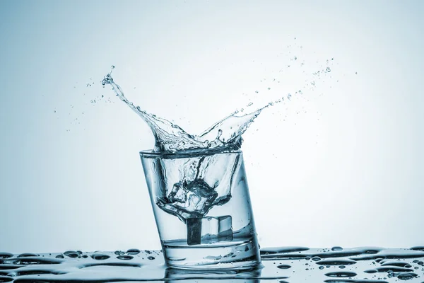 Agua en vaso con agua salpicada — Foto de Stock