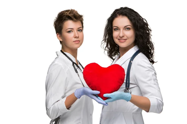 Two doctors holding a red heart — Stock Photo, Image