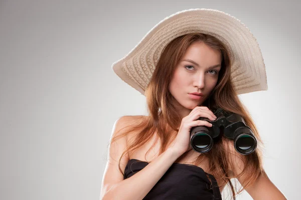 Jovem mulher de chapéu com binóculos — Fotografia de Stock