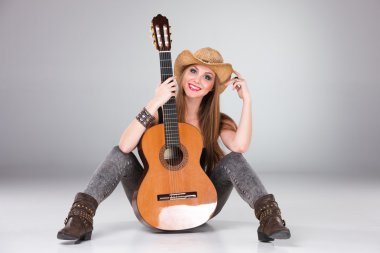 Bir kovboy şapkası ve akustik gitar güzel kız.