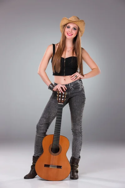 A menina bonita em um chapéu de cowboys e guitarra acústica . — Fotografia de Stock