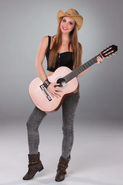 A menina bonita em um chapéu de cowboys e guitarra acústica . — Fotografia de Stock