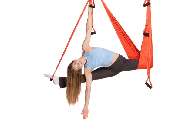 Jonge vrouw doet anti-zwaartekracht luchtfoto yoga in hangmat op een naadloze witte achtergrond. — Stockfoto
