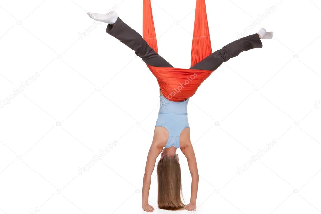 Young woman making antigravity yoga exercises in stretching twine