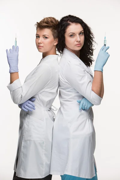 Portrait of two women surgeons showing syringes — Stock Photo, Image