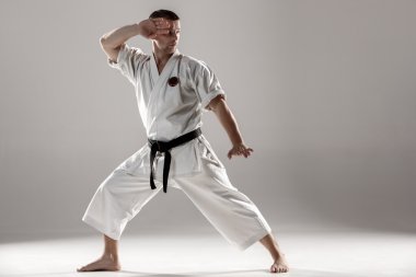 Man in white kimono training karate clipart