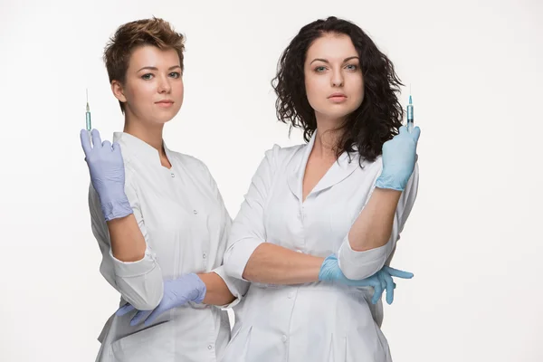 Retrato de duas mulheres cirurgiãs mostrando seringas — Fotografia de Stock