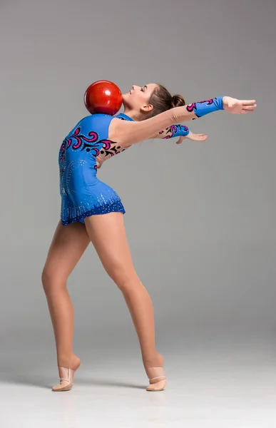 Tiener doen gymnastiek oefeningen met rode gymnastiek bal — Stockfoto