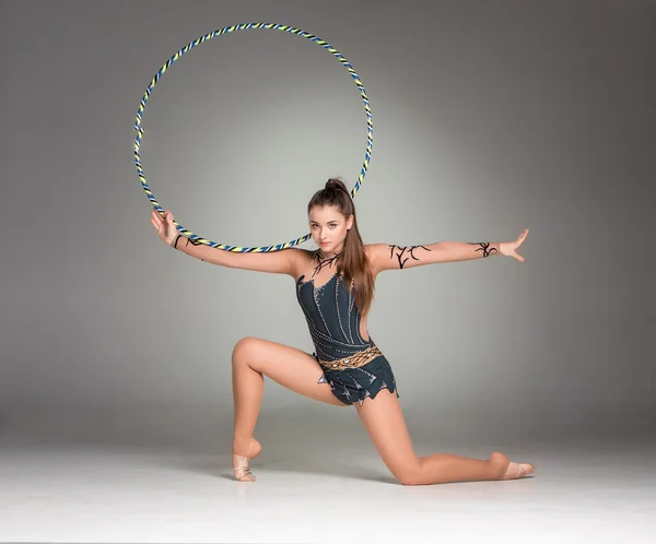Tonåring gör gymnastik övningar med färgglada band — Stockfoto