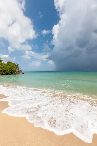 Praia na ilha tropical. Água azul clara, areia, nuvens . — Fotografia de Stock