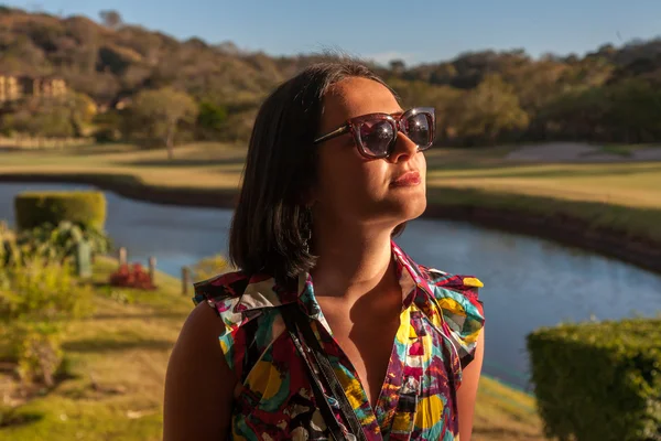 Young woman in sunglasses enjoying summer breeze at beach. — Stock Photo, Image