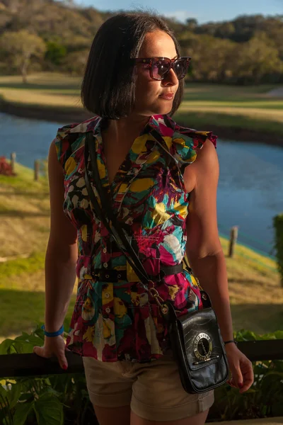 Young woman in sunglasses enjoying summer breeze at beach. — Stock Photo, Image