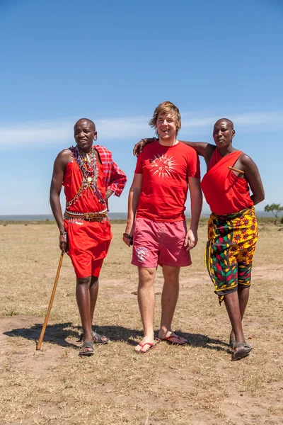 MASAI MARA, KENYA, AFRICA- FEB 12 uomini Masai in abiti tradizionali e turisti europei — Foto Stock