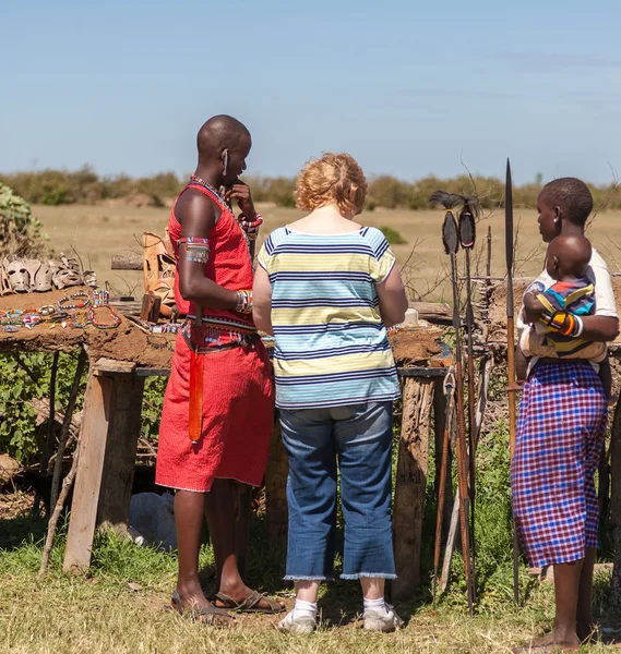 MASAI MARA, KENYA, AFRICA- FEB 12 Masai uomo e donna in abiti tradizionali e turisti europei, rassegna della vita quotidiana della popolazione locale, vicino alla Masai Mara National Park Reserve, 12 Feb 2010, Kenya — Foto Stock