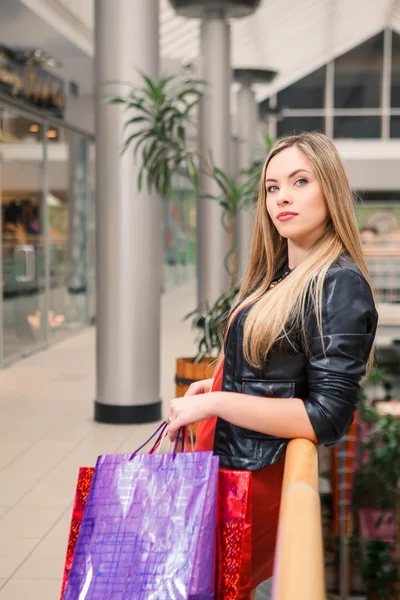 Mooie jonge vrouw met een shopping tassen in het winkelcentrum — Stockfoto