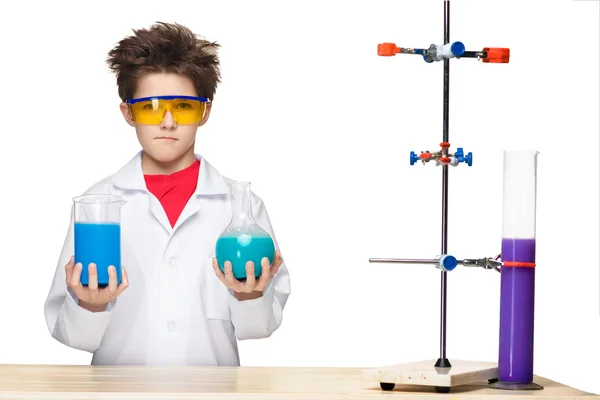 Niño pequeño como químico haciendo experimentos con fluidos químicos en el laboratorio —  Fotos de Stock