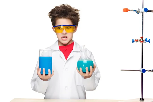 Маленький мальчик-химик проводит эксперименты с химической жидкостью в лаборатории — стоковое фото