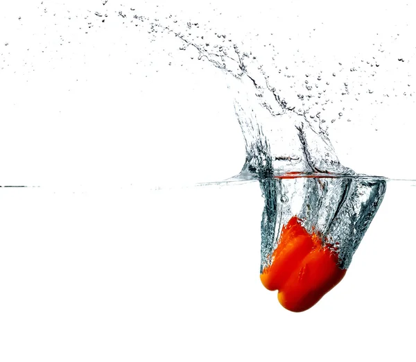 Pepper drops into a water — Stock Photo, Image