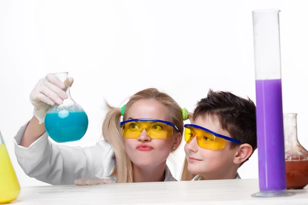 Teen and teacher of chemistry at  lesson making experiments — Stock Photo, Image