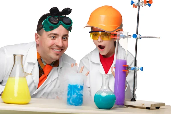 Teen and teacher of chemistry at  lesson making experiments — Stock Photo, Image