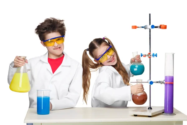 Два милых ребенка на уроке химии проводят эксперименты — стоковое фото