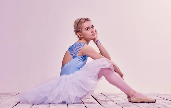 Müde Balletttänzerin sitzt auf dem Holzboden — Stockfoto