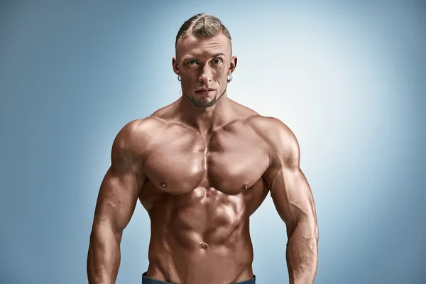 Aantrekkelijke mannelijke lichaam bouwer op blauwe achtergrond — Stockfoto