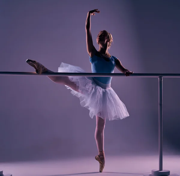 Klasická baletka pózuje na balet barre — Stock fotografie