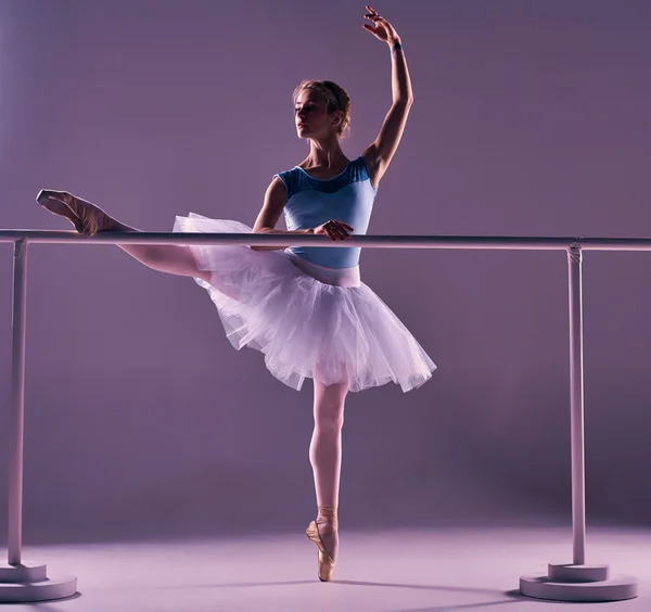 Bailarina clásica posando en la barra de ballet —  Fotos de Stock