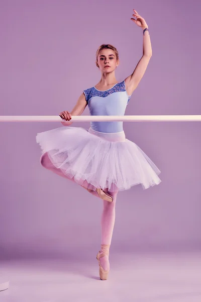 Bailarina clásica posando en la barra de ballet —  Fotos de Stock