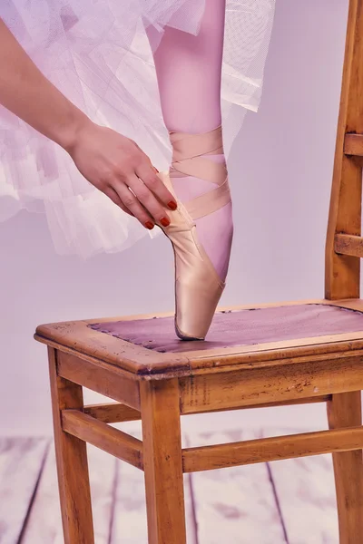 Professional ballerina putting on her ballet shoes.