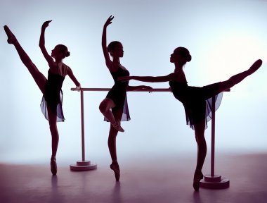 Ballerinas stretching on the bar clipart