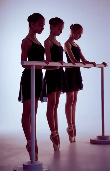 Ballerinas dehnen sich auf der Stange — Stockfoto