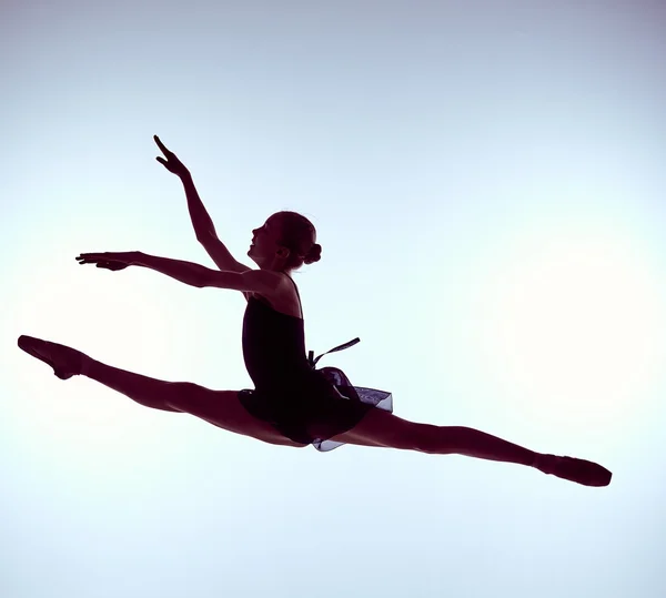 Belle jeune danseuse de ballet sautant sur un fond gris . — Photo