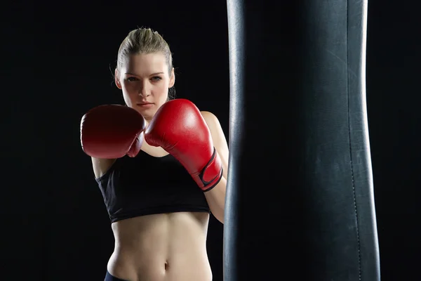 Beautiful woman is boxing on black background — Stock Photo, Image