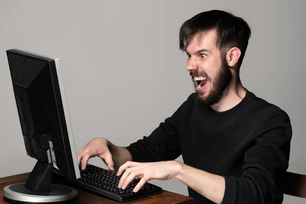 Смішний і божевільний чоловік використовує комп'ютер — стокове фото